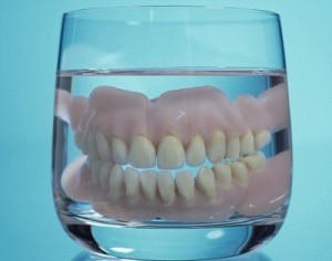 Nuotrauka: protezo valymas stiklinėje vandens