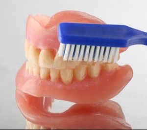 Foto: curățarea unei proteze amovibile cu o periuță de dinți convențională
